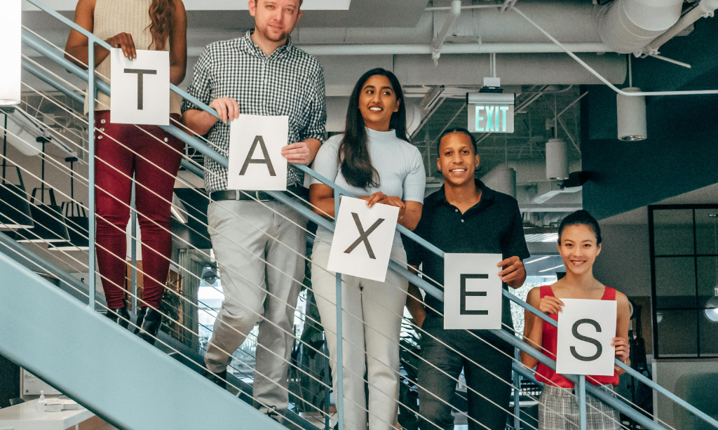 Team holding letters spelling TAXES