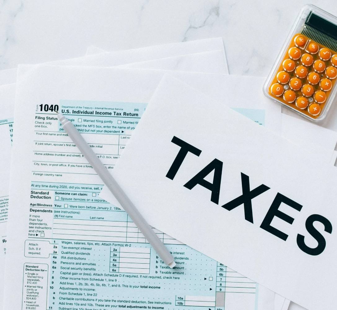 U.S. tax return forms, calculator, and tax documents on a desk